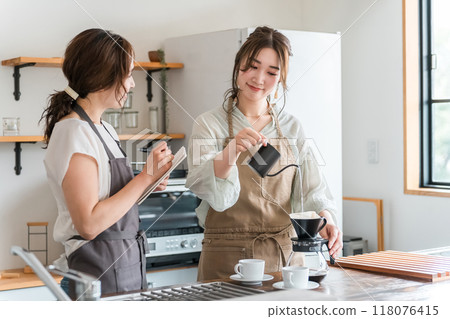 A female instructor and a female student teaching how to make coffee at a coffee class/school 118076415