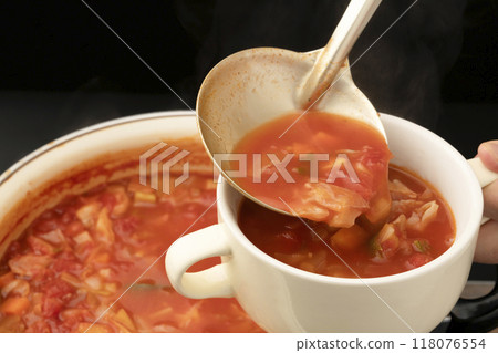 Pour the minestrone soup into cups and serve. 118076554