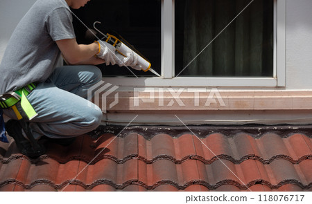 Construction worker using silicone sealant caulk for repair leaked inside window frame. Construction worker using silicone sealant caulk for repair leaked inside window frame. 118076717