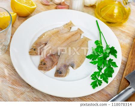 Spotted flounder served with parsley on plate 118078314