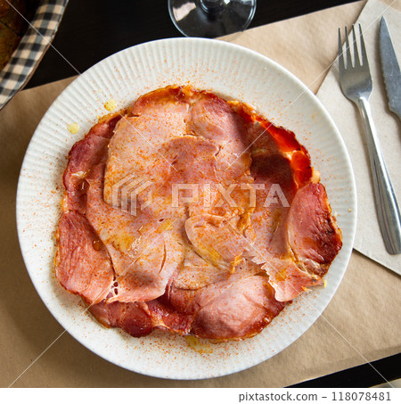 Slices of Lacon gallego with sweet paprika on plate 118078481