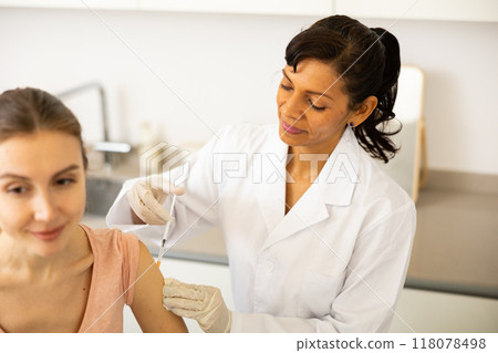 Woman doctor vaccinating patient Woman doctor vaccinating patient 118078498