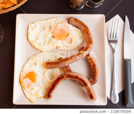Homemade hearty breakfast - fried eggs with frankfurter sausages butifarra Homemade hearty breakfast - fried eggs with frankfurter sausages butifarra 118078509