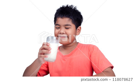 Concept of happy good nutrition, Portrait of a little young handsome kid boy in pink t-shirt, Holding a glass of milk on white background, Smiling of Asian boy with a glass of milk. 118078627