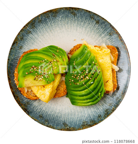 Hearty sandwich with toast, cheese, plate of egg omelet and pieces of avocado 118078668
