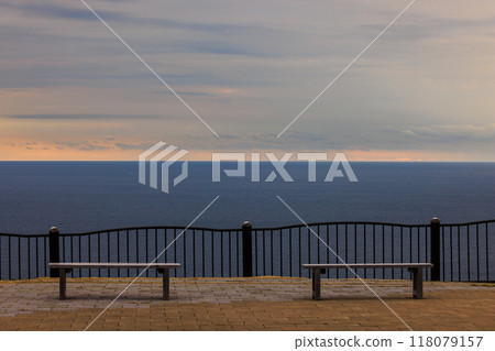 Sunset over the sea and a bench Sunset over the sea and a bench 118079157