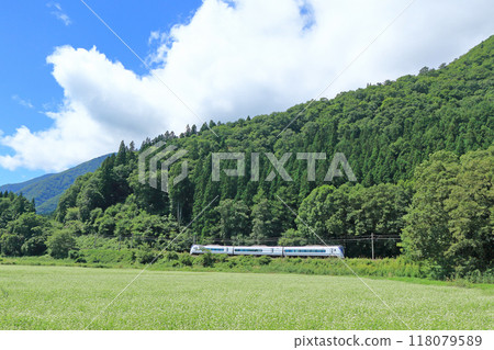 The Azusa Express train travels through the foothills of Mount Hakuba in early autumn 118079589