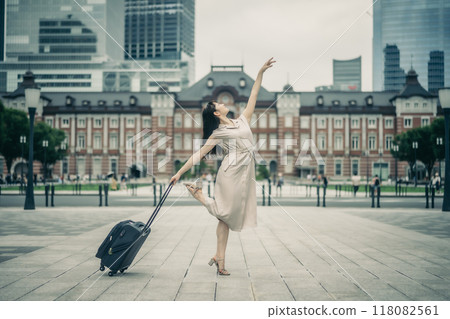 一位年輕女子拎著隨身行李去旅行，看起來很興奮。 118082561