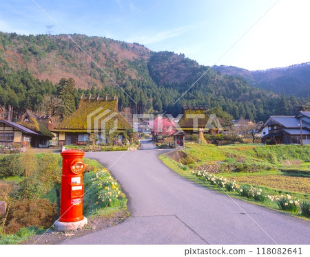 Spring scenery of Miyama Kayabuki Village, Mackerel Highway, "Nationally designated Important Preservation District for Groups of Traditional Buildings" / Retro red round post Spring scenery of Miyama Kayabuki Village, Mackerel Highway, "Nationally designated Important Preservation District for Groups of Traditional Buildings" / Retro red round post 118082641
