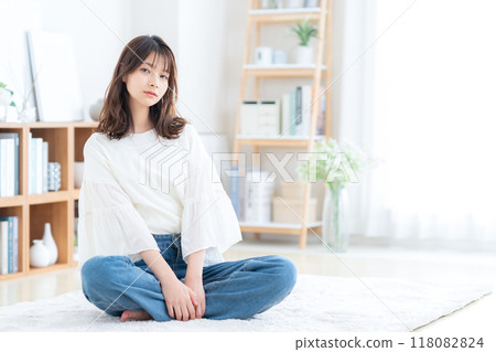 Young woman sitting and relaxing in living room 118082824