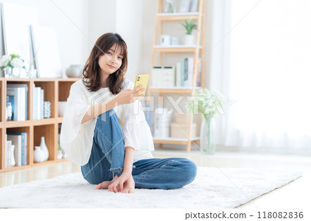 坐在客廳裡放鬆的年輕女人 118082836