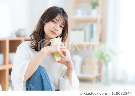 Young woman sitting and relaxing in living room 118082844