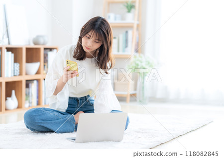 坐在客廳裡放鬆的年輕女人 118082845