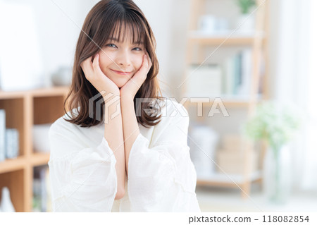 Young woman sitting and relaxing in living room 118082854