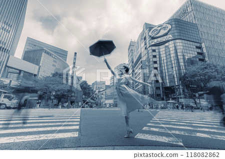 一名女子在緊急十字路口撐著遮陽傘穿過行人穿越道 118082862