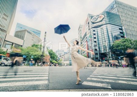 A woman crossing the street with a parasol at a scramble intersection 118082863
