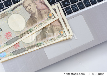 An image of freely developing business online using the internet with a computer keyboard and a 10,000 yen note An image of freely developing business online using the internet with a computer keyboard and a 10,000 yen note 118083884
