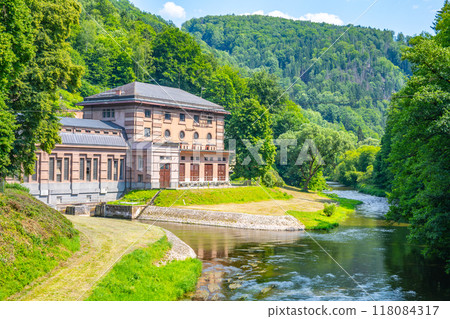 The Spalov Hydroelectric Power Plant stands alongside a tranquil river, surrounded by verdant hills in Czechia, showcasing the harmony between nature and renewable energy production. The Spalov Hydroelectric Power Plant stands alongside a tranquil river, surrounded by verdant hills in Czechia, showcasing the harmony between nature and renewable energy production. 118084317