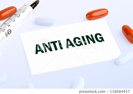 Words ANTI AGING on a white business card lying on a light background Words ANTI AGING on a white business card lying on a light background 118084457