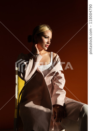 Beautiful fashionable slim blonde woman sitting on a chair 118084790