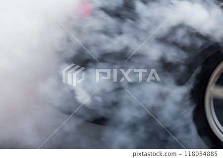 White smoke from tire, Car burnout wheels tire with white smoke,Car wheel burnout with smoke from the spinning tyre, Drag car wheel burns tires preparation for the race. 118084885