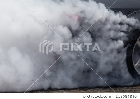 White smoke from tire, Car burnout wheels tire with white smoke,Car wheel burnout with smoke from the spinning tyre, Drag car wheel burns tires preparation for the race. 118084886