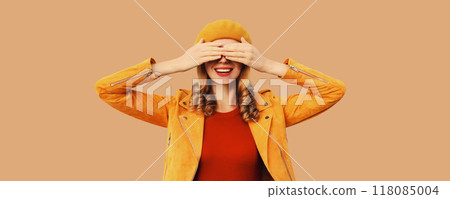 Stylish surprised young woman covering her eyes with hands, fashionable girl in orange hat, jacket Stylish surprised young woman covering her eyes with hands, fashionable girl in orange hat, jacket 118085004
