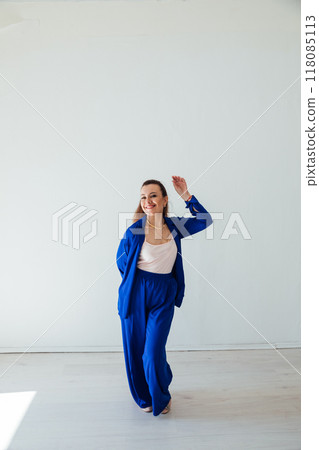 Beautiful woman in blue summer suit in white room 118085113