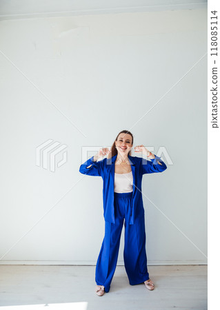 Beautiful woman in blue summer suit in white room Beautiful woman in blue summer suit in white room 118085114