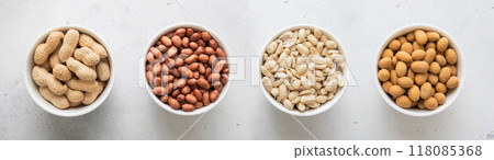Whole and peeled with blanched and salted peanut nuts in bowls on light background.Top view. 118085368