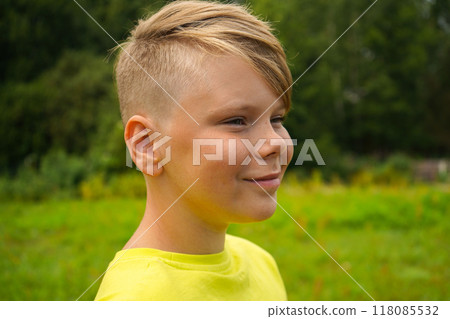 Portrait of a boy in a yellow T-shirt smiling in nature on a sunny summer day 118085532