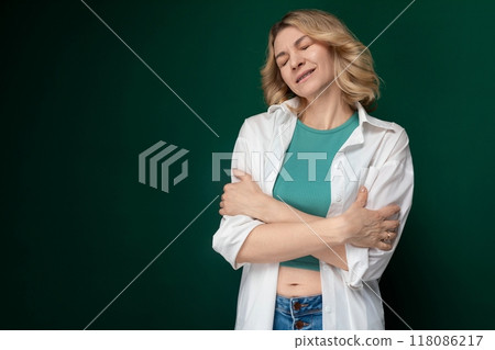 Woman Standing With Arms Crossed in Front of Green Background 118086217
