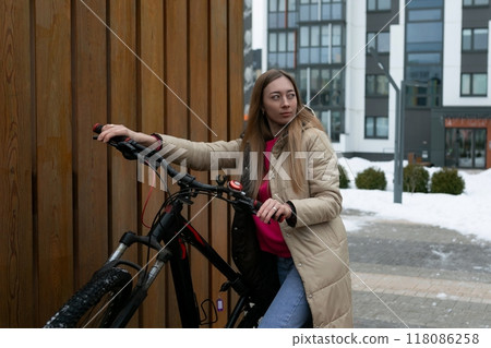 Woman Standing Next to Bike in Snow Woman Standing Next to Bike in Snow 118086258