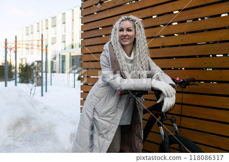 Woman Standing Next to Bike in Snow 118086317