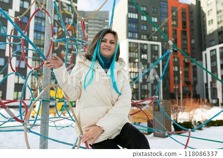 Woman Sitting on Top of Pole in Snow 118086337
