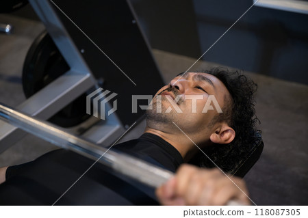 Man training at the gym raising dumbbells Man training at the gym raising dumbbells 118087305