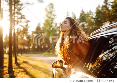Happy woman on summer trip, travels leaning out of the car window. Active lifestyle. Travel concept. 118087365