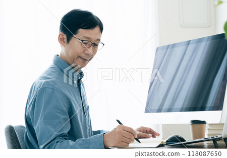 Middle-aged man operating a computer at home Middle-aged man operating a computer at home 118087650