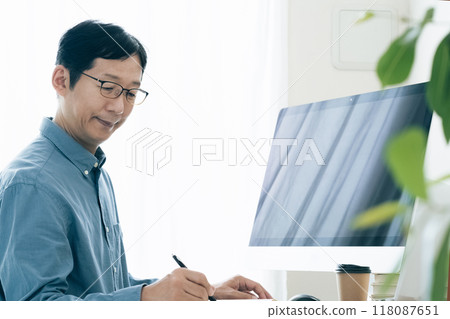 Middle-aged man operating a computer at home Middle-aged man operating a computer at home 118087651