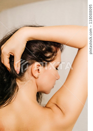 A woman with long hair is looking at the camera. She has a serious expression on her face. A woman with long hair is looking at the camera. She has a serious expression on her face. 118088095