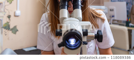 woman gynecologist working with colposcope 118089386