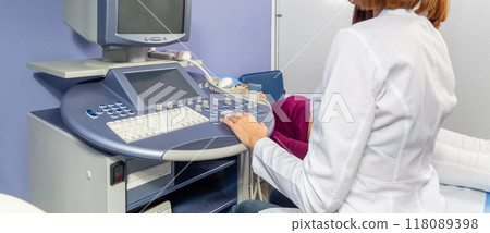 The doctor performs an ultrasound diagnosis of the abdominal cavity of a pregnant girl at an early stage of pregnancy. The doctor performs an ultrasound diagnosis of the abdominal cavity of a pregnant girl at an early stage of pregnancy. 118089398