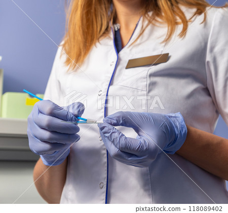 Doctor in gloves holds brush for smears and glass in laboratory. Doctor in gloves holds brush for smears and glass in laboratory. 118089402