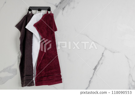 Set of Hanging Towels on Marble Bathroom Wall 118090553