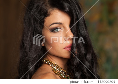 Indoor portrait of young adult woman with long wavy hair and make-up Indoor portrait of young adult woman with long wavy hair and make-up 118090805