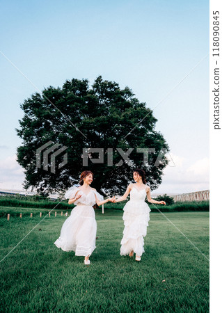 Pre-wedding photo shoot of same-sex couple running in nature 118090845