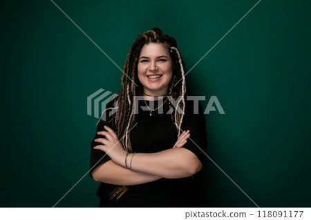 Woman With Dreadlocks Standing in Front of Green Wall Woman With Dreadlocks Standing in Front of Green Wall 118091177