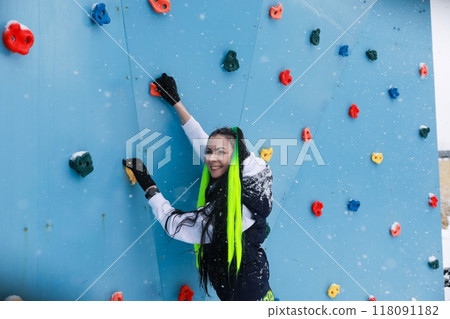 Woman Climbing Up Climbing Wall 118091182
