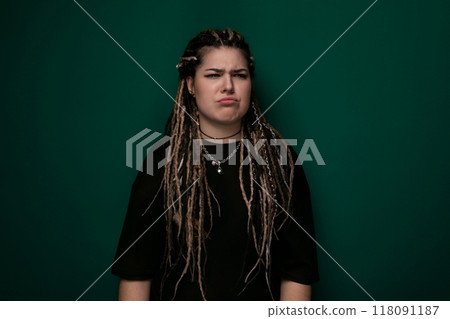 Woman With Dreadlocks Standing in Front of Green Wall 118091187
