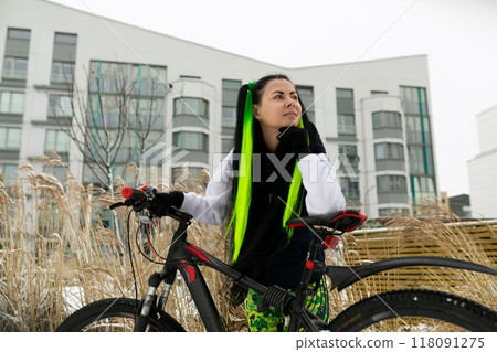 Woman With Green Scarf Standing Next to Bike Woman With Green Scarf Standing Next to Bike 118091275